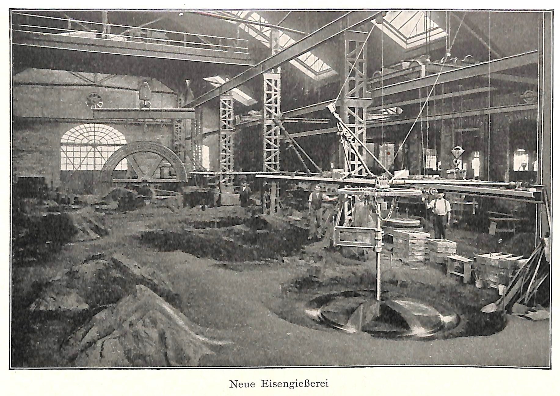 Schwarz-weiß-Foto einer Fabrik mit Arbeitern, die Maschinen bedienen, umgeben von Metallstangen und -pfählen, beschriftet mit 'Neue Eisenglebeerei, die erste Fabrik in Deutschland' unten.