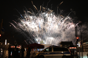 Polizeiauto vor Menschenmenge bei Silvesterfeier in Berlin geparkt