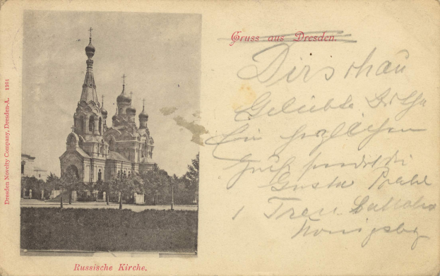 Eine schwarz-weiße Postkarte mit der Kirche des Erlösers auf dem Blutsstein in Dresden, umgeben von Bäumen unter einem klaren blauen Himmel, mit deutschem Text auf der rechten Seite.
