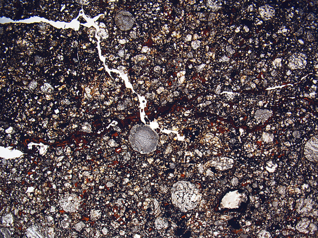 Nahaufnahme einer schmutzigen, zerklüfteten Straße mit einer rauen, unebenen Oberfläche.