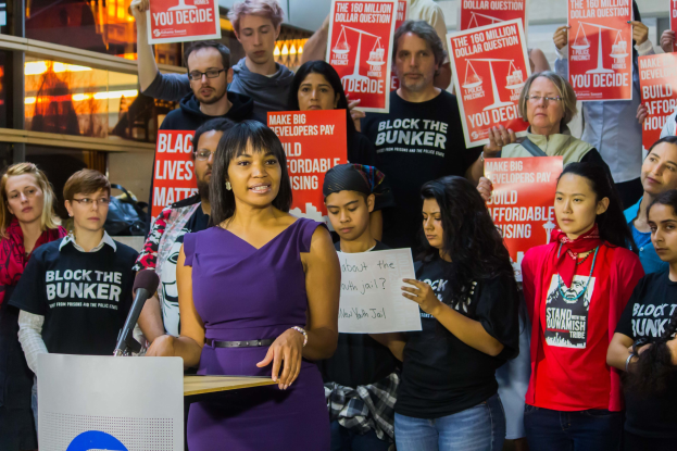 Eine Black Lives Matter-Aktivistin spricht vor einer Menge mit Mikrofon an einem Rednerpult.