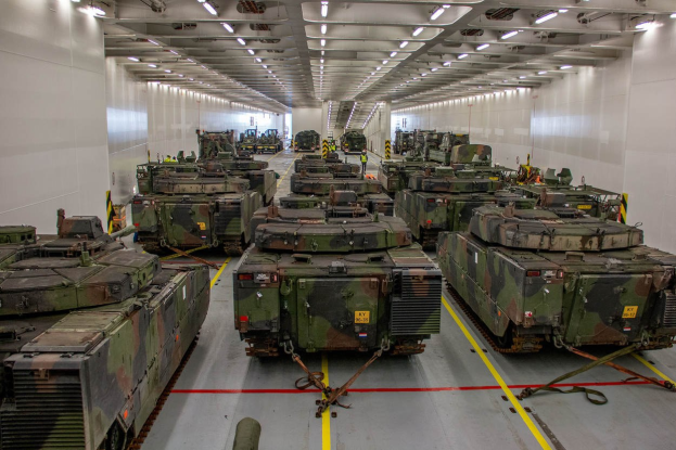 Ein grosser Militaraustellungsraum mit Reihen von Militaraerzten, beleuchtet von Deckenleuchten und von Waenden umgeben.