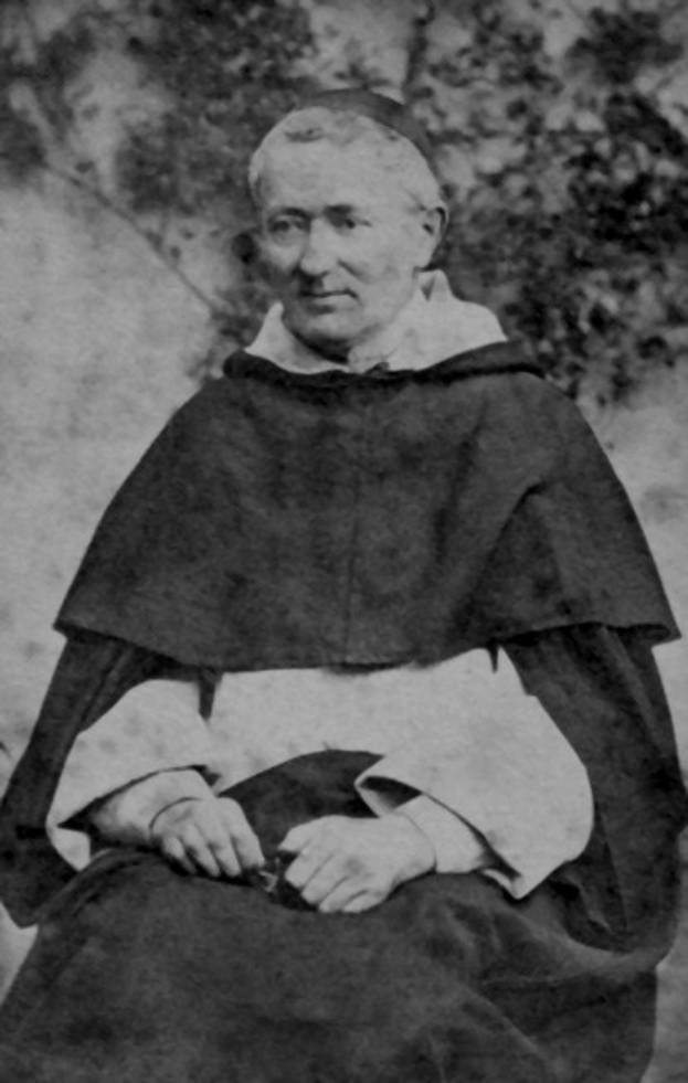 Ein Schwarz-Weiß-Foto eines alten Mannes in Priesterrobe, der draußen mit gefalteten Händen betet, trägt eine schwarze Robe mit weißem Kragen und Manschetten, beleuchtet von warmem Licht mit einem friedlichen Gesichtsausdruck.