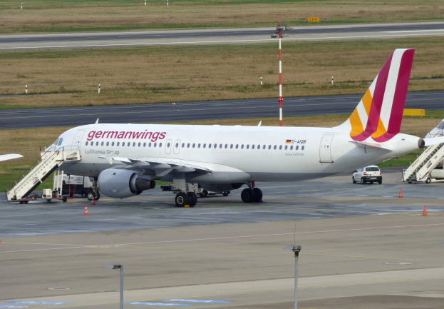 Ein Airbus A320-200 der Germanwings auf dem Frankfurt Airport geparkt, mit Fahrzeugen, Verkehrskegeln, Pfosten und Gras im Hintergrund.