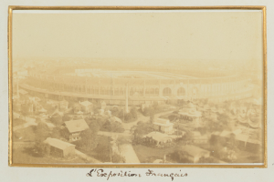 Altes Schwarz-Weiß-Foto eines Stadions inmitten einer Stadtlandschaft, umgeben von Gebäuden, Bäumen und Strommasten, mit Text am unteren Rand.
