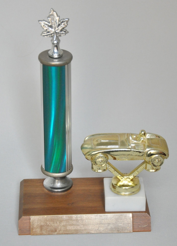 Ein glänzendes, detailliert gearbeitetes Modellauto auf einem Trophy, das auf einer hellen Holzplatte steht.