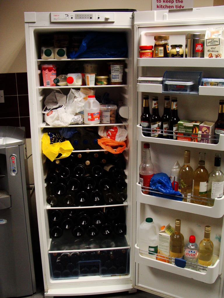 Ein offener Kühlschrank mit Weinflaschen und verschiedenen anderen Gegenständen.