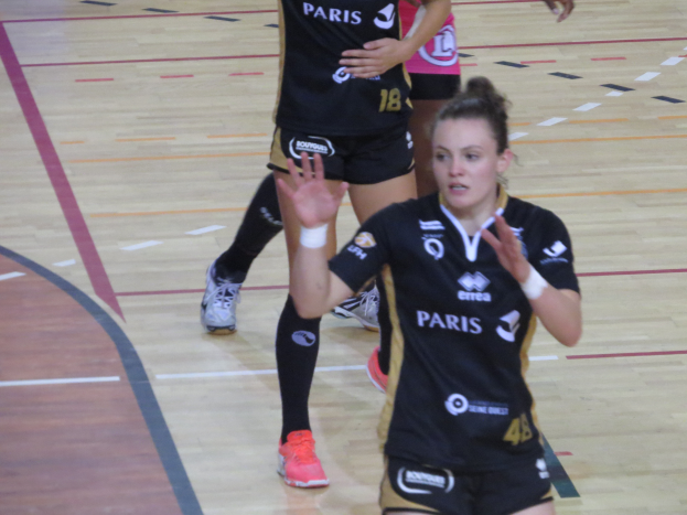 Eine Gruppe von Frauen in Sportkleidung beim Volleyballspielen auf einem Feld.