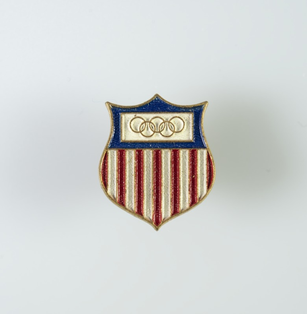 Eine weiße Fläche mit einem Abzeichen, das das ikonische Audi-Logo in der Mitte zeigt, umgeben von einem roten, weißen und blauen Schild.