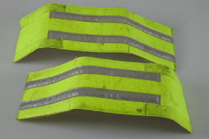 Zwei gelbe reflektierende Sicherheitswesten auf einer weißen Fläche.