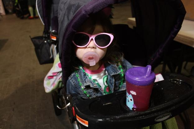 Ein Kind sitzt in einem Rollstuhl auf der Straße.