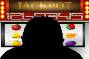 Ein Mann spielt an einem Automaten mit der Aufschrift "Jackpot", umgeben von einer Tafel mit Text und Bildern von Früchten, was auf Online-Casino-Spiele hinweist.