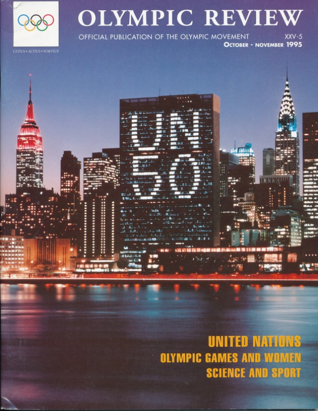 Ein Buch mit dem Titel "Olympic Review Official Publication of the Olympic Movement" liegt auf einer flachen Oberfläche, mit einer Stadtlandschaft mit Gebäuden, Lichtern und Wasser auf dem Cover, und der Text "United Nations Olympic Games and Women Science and Sport" ist ebenfalls sichtbar.