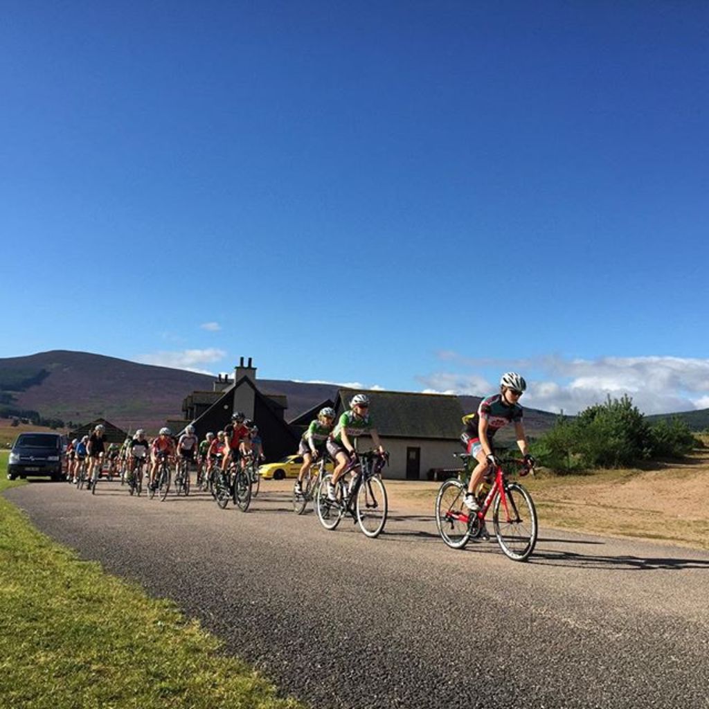 Eine Gruppe von Menschen, die mit dem Fahrrad fahren und der Himmel im Hintergrund.