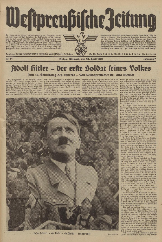 Adolf Hitler, gekleidet in einem schwarzen Anzug und weißem Hemd, steht vor einer Menge auf der Titelseite einer deutschen Zeitung mit der Schlagzeile "Adolf Hitler - Der Erte Soldat Feines Volkes".