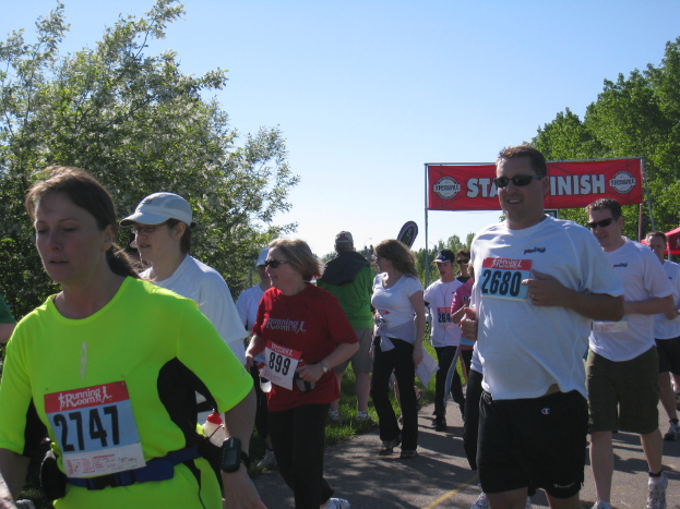 Eine Gruppe von Kindern beim Marathonlauf, mit einem roten Banner und Bäumen im Hintergrund.