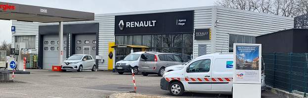 Ein Renault-Autohaus mit parkenden Autos davor, umgeben von einem Metallzaun.