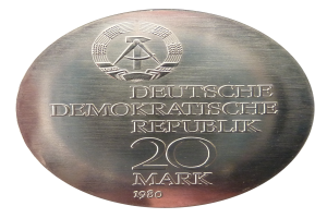 Eine Silbermedaille mit der Aufschrift 'Deutsche Demokratische Republik' vor einem weißem Hintergrund.