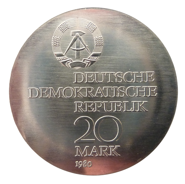 Eine Silbermedaille mit der Aufschrift 'Deutsche Demokratische Republik' vor einem weißem Hintergrund.