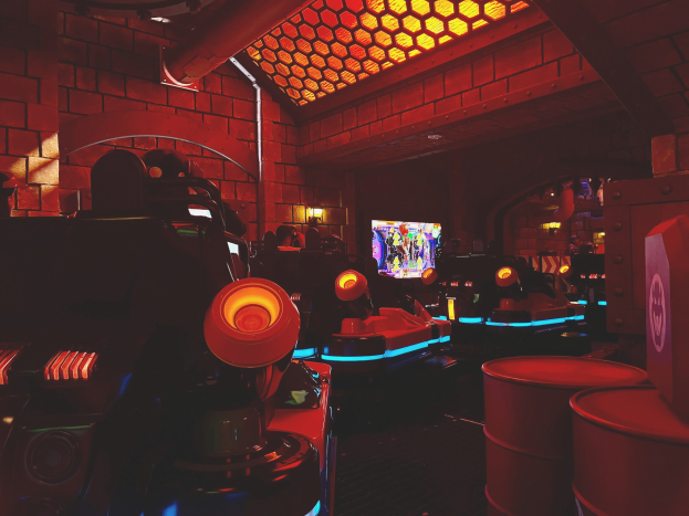 Ein heller Raum voller verschiedener Arcade-Videospielautomaten, Bildschirme und andere Geräte, die eine energische Atmosphäre schaffen.