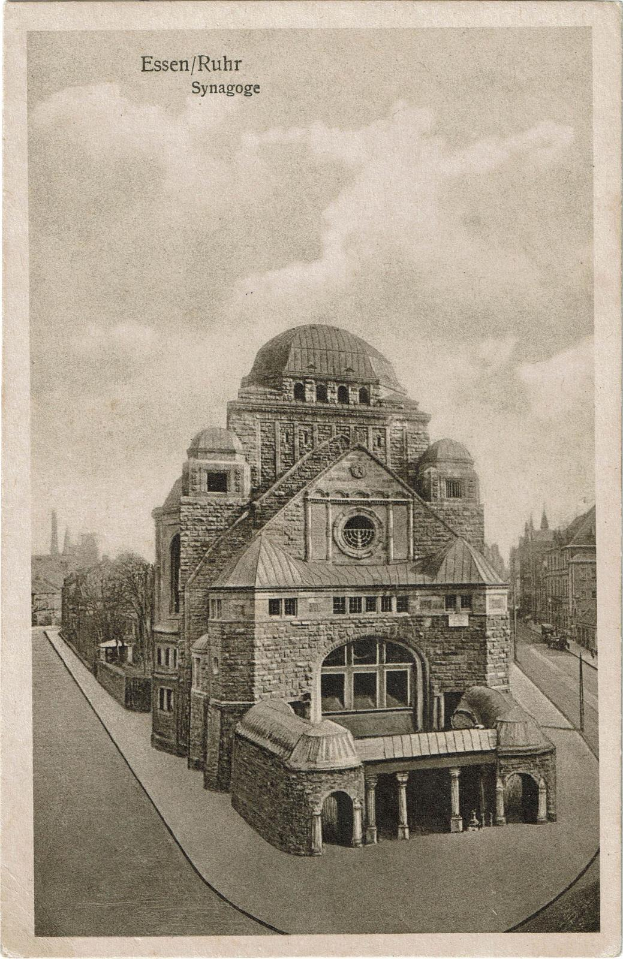 Ein altes Schwarz-Weiß-Foto eines Kuppelgebäudes, identifiziert als die Essen/Ruhr-Synagoge, umgeben von Bäumen und einem bewölkten Himmel.