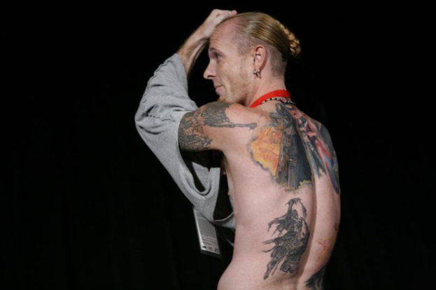 Eine Person mit mehreren sichtbaren Tattoos.