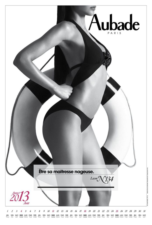 Eine Frau steht mit einem Röhrchen in der Hand, mit sichtbarem Text und einem Datum in der unteren linken Ecke vor einem weißen Hintergrund.