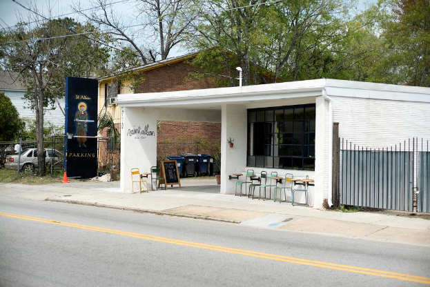 Ein Restaurant, das an einer Straße mit Bäumen im Hintergrund liegt.