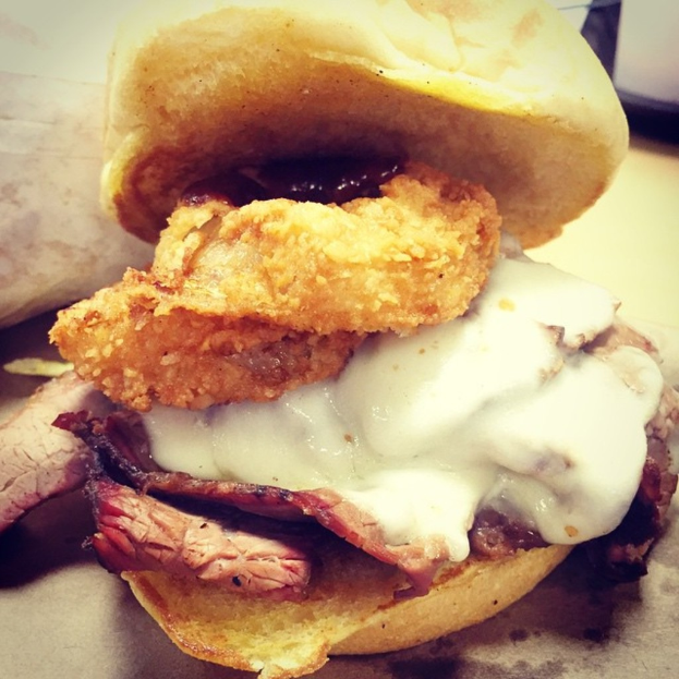 Verschiedene Brotsorten und ein Becher mit Sahne auf einem Tisch.