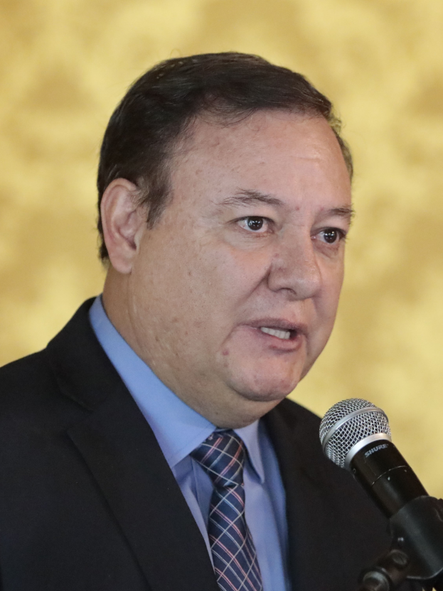 Ein Mann im Anzug und mit Krawatte spricht in ein Mikrofon, identifiziert als Generalstaatsanwalt.