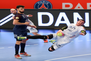 Eine Gruppe von Männern spielt Handball auf einem Court, einer hält den Ball, im Hintergrund ein Paris Saint-Germain Futsal-Team-Schild.