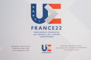 Ein Plakat mit dem Text 'Frankreich 22 - Inoffizielles Treffen der Außenminister' und dem Logo der Europäischen Union, das ein blauer Kreis mit einem weißen Rand, einem weißen Stern in der Mitte und einem weißen Rand ist.