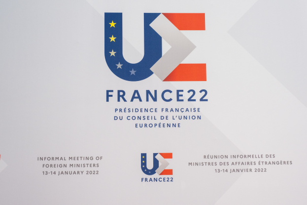Ein Plakat mit dem Text 'Frankreich 22 - Inoffizielles Treffen der Außenminister' und dem Logo der Europäischen Union, das ein blauer Kreis mit einem weißen Rand, einem weißen Stern in der Mitte und einem weißen Rand ist.