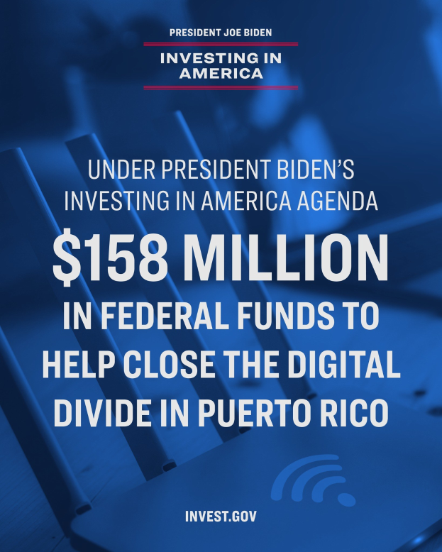 Plakat mit der Aufschrift "Im Rahmen des Investing in America-Programms von Präsident Biden: 158 Millionen Bundesmittel, um die digitale Kluft in Puerto Rico zu schließen" mit einem Laptop, Papieren und einem Kaffeebecher auf einem Tisch davor.